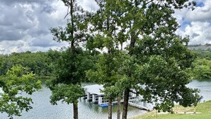 A grassy area with trees and a lake view.