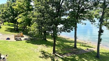 A lakeside park with picnic tables and a playground.