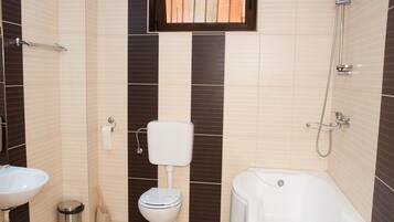 A bathroom with a toilet, sink, and bathtub.