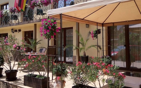 A hotel named Vila Alma with outdoor seating and potted plants.