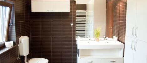 Un baño moderno con inodoro, lavamanos y mueble.