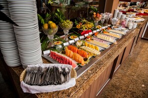 A buffet with various food items and utensils.