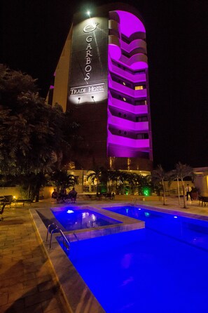 Un hôtel doté d’une piscine et d’une enseigne indiquant « GARBOS Trade Hotel ».