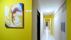 A hallway with yellow walls, a painting, and a sign indicating room number 2. - Hotel Imperial (Mossoro)