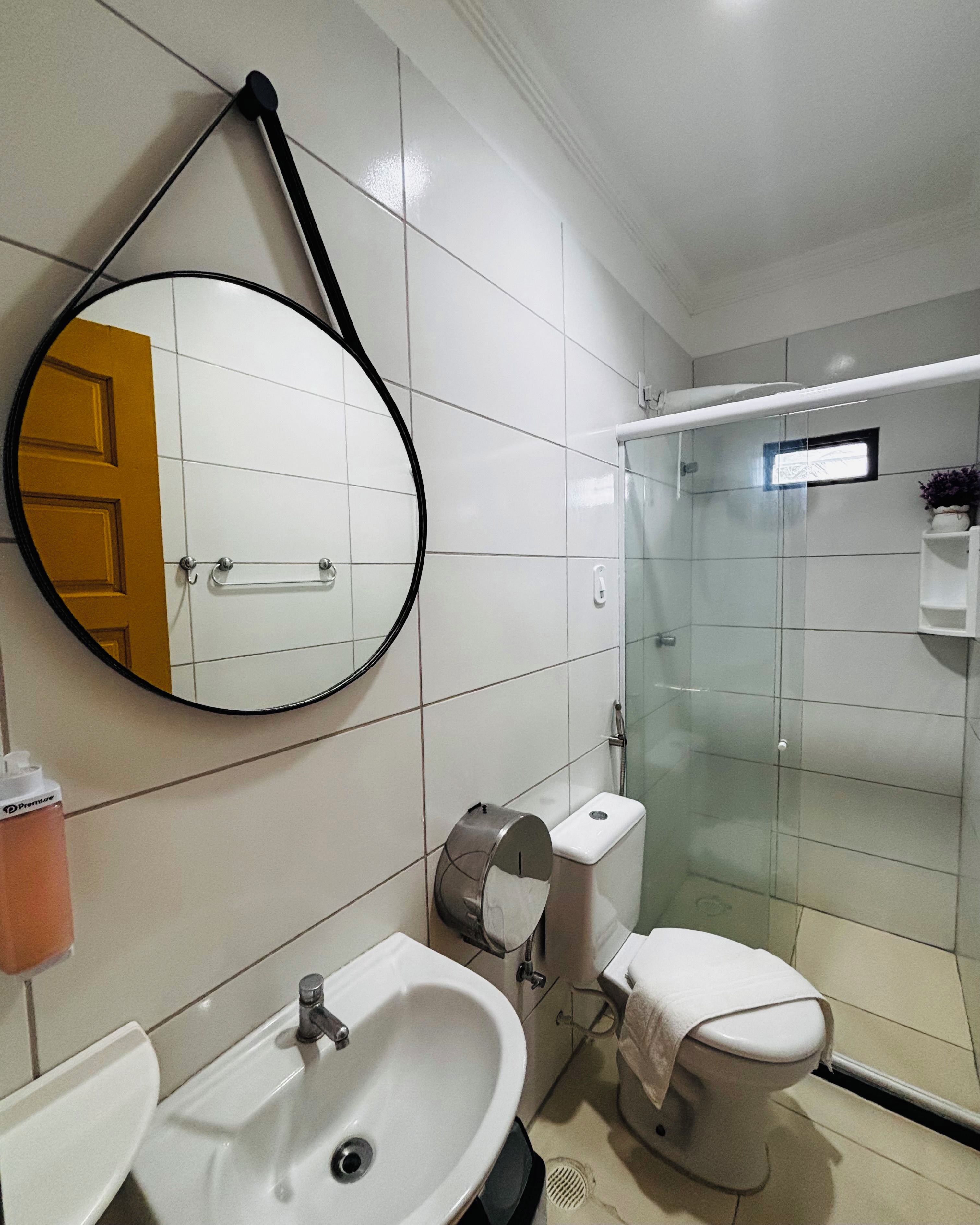 A bathroom with a toilet, sink, and a glass-enclosed shower stall.