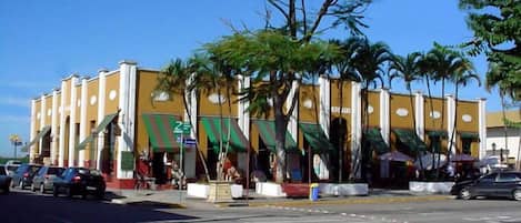 A multi-story building with a yellow facade and green awnings.