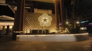 Entrada de un hotel con un gran letrero iluminado que dice "BYTHESEA".