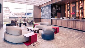 Een moderne lounge met zitplaatsen, een bar en uitzicht over de stad.