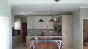 Una cocina moderna con una isla central, luces colgantes y muebles empotrados.