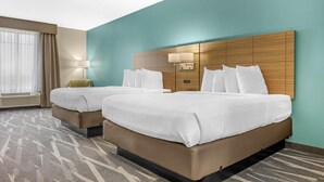 A hotel room with two beds, a large window with curtains, a wall-mounted lamp, and a patterned carpet. - Best Western Plus Centralia Hotel & Suites (Centralia)
