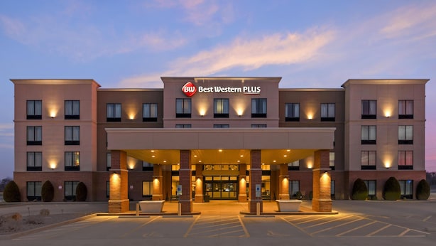 A multi-story hotel with a central entrance, illuminated by exterior lights, and a clear sky in the background. - Best Western Plus Centralia Hotel & Suites (Centralia)
