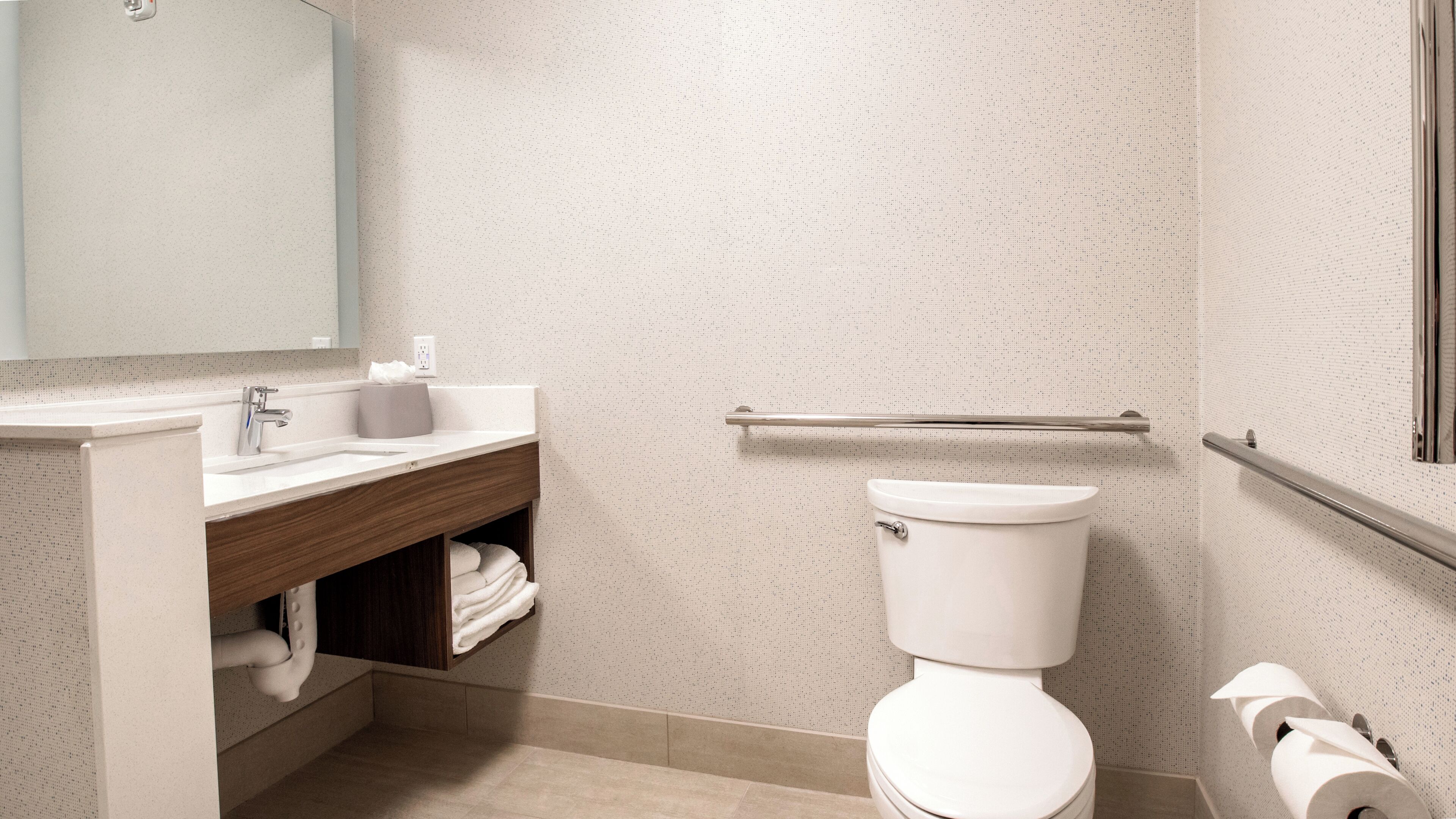 Une salle de bain équipée de toilettes, d’un lavabo et d’un porte-serviettes.