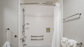 A bathroom with a shower, toilet, and towel rack.