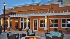 An outdoor patio area with a fire pit, wicker furniture, and a pergola. - Residence Inn by Marriott Oklahoma City Airport (Oklahoma City)