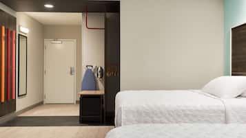 Een hotelkamer met een bed, een bureau en een deur.