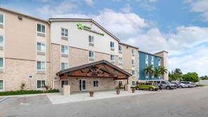 Een AmeriSuite hotel met een stenen gevel, een overdekte ingang en een parkeerplaats.