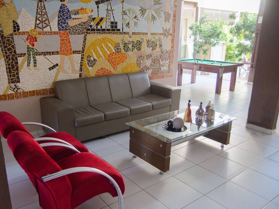 A living room with a sofa, a glass coffee table, and a colorful mosaic wall.
