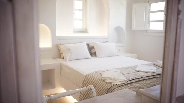 A bedroom with a bed, nightstands, and a window. - Paraporti Hotel (Folegandros)