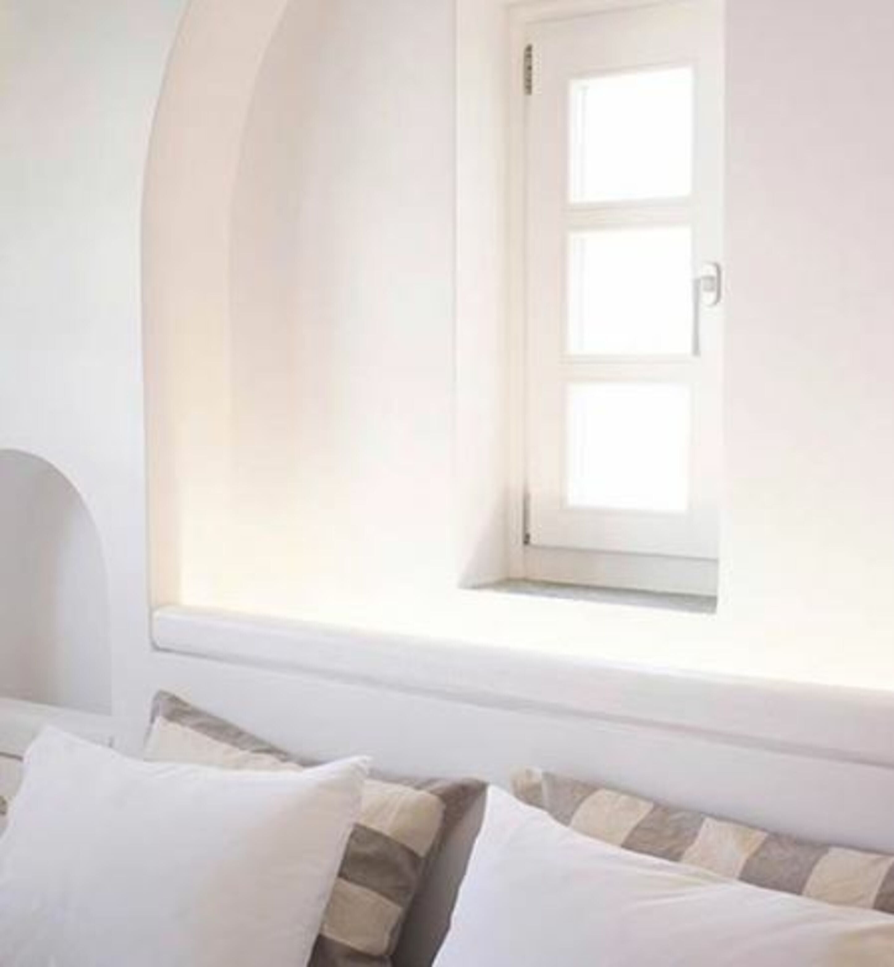 Ein Zimmer mit einem Bett, einem Fenster mit Blick und einer Tür.