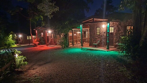 A rustic outdoor area with a stone building, a wooden bench, and a pathway. - Estrella del Monte (Puerto Iguazú)