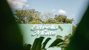 A sign with the text "Estrella del Monte" partially obscured by foliage. - Estrella del Monte (Puerto Iguazú)