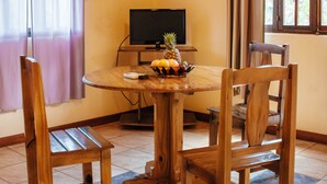 A wooden dining table with chairs, a television, and a fruit bowl. - Estrella del Monte (Puerto Iguazú)