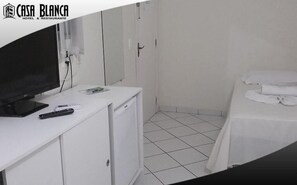 Minibar, escritorio, cortinas blackout y tabla de planchar con plancha