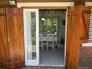 Puerta de madera que da a un comedor con mesa y sillas.