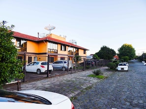 A residential street with houses, parked cars, and a cobblestone road. - Morada do Centro Apartamento (Canela)