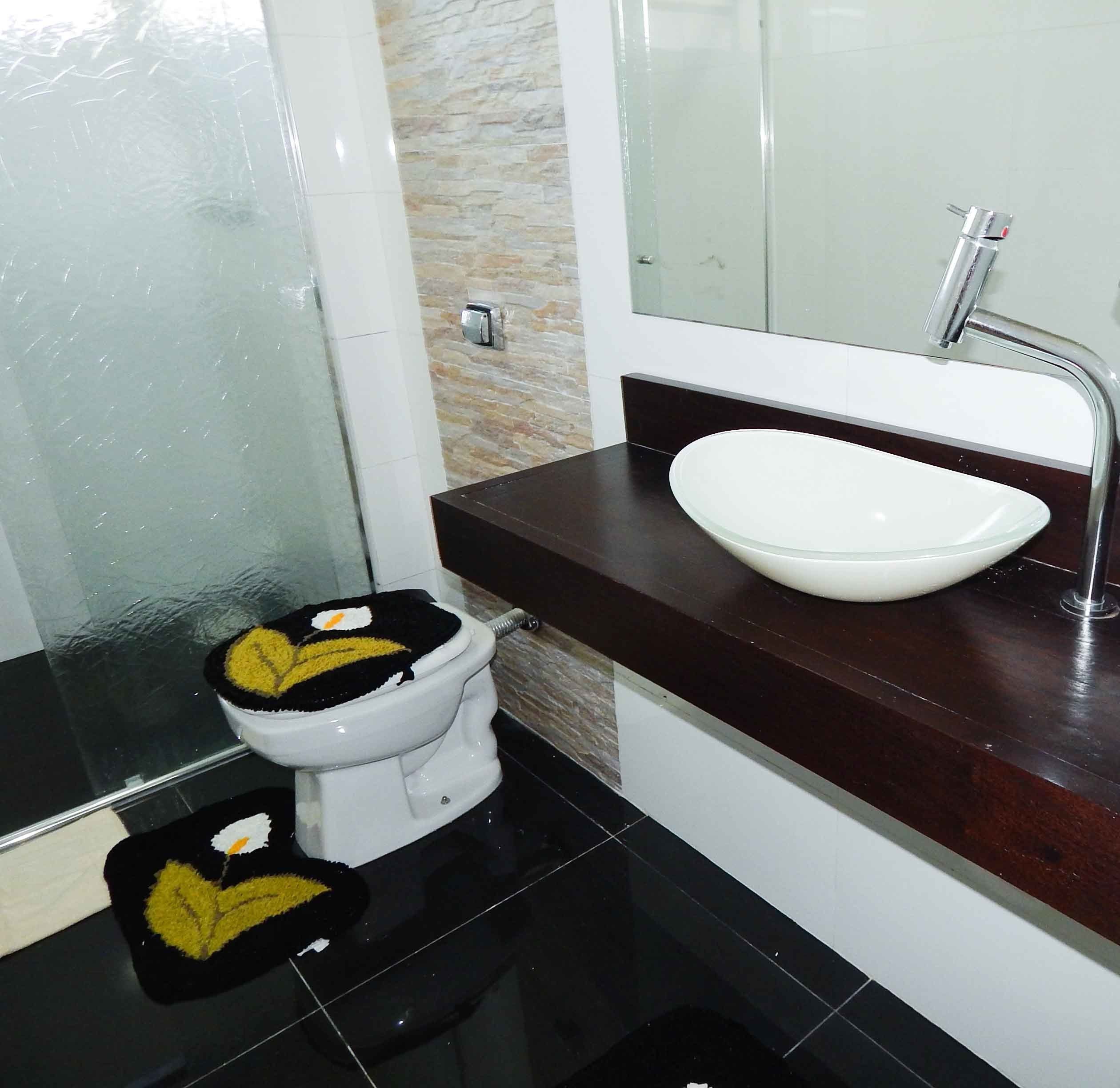 Un baño con inodoro, lavamanos y espejo.