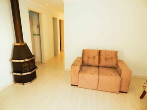 A room with a sofa and a wood-burning stove. - Morada do Centro Apartamento (Canela)