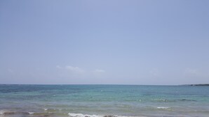 A beach with clear blue water and a distant shoreline. - Ocho Rios Villa at Coolshade X (St. Ann's Bay)
