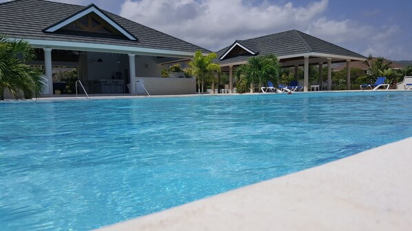 A swimming pool with lounge chairs and a covered area with a roof. - Ocho Rios Villa at Coolshade X (St. Ann's Bay)