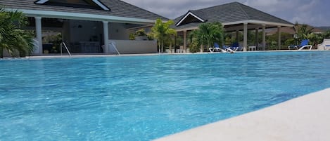 Utomhuspool, parasoller och solstolar