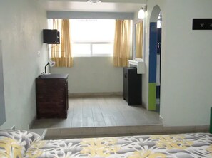 A bedroom with a bed, a dresser, a mirror, and a window with curtains. - Hotel & Villas 7 (Mexico City)
