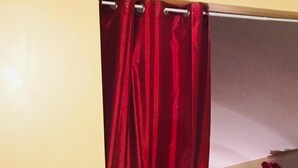 Un sofá amarillo en una habitación con una cortina roja.