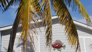 A white building with a mural of a fish, a golf cart, and a palm tree. - Dock, Htd 80' Pool, Deep Channel, 15 Min To Key West  (Cudjoe Key)