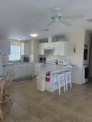 A kitchen with white cabinets, a ceiling fan, a microwave, and a coffee maker. - Dock, Htd 80' Pool, Deep Channel, 15 Min To Key West  (Cudjoe Key)