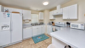 A modern kitchen with white cabinets, a refrigerator, a microwave, a toaster, and a sink. - Dock, Htd 80' Pool, Deep Channel, 15 Min To Key West  (Cudjoe Key)