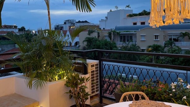 A rooftop terrace with a round table, chairs, and a hanging light fixture. - Extraordinary  Retreat In Cartagena. Casa Kava (Cartagena)