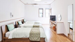 A hotel room with two beds, a desk with a computer, a TV, and a mirror. - Mantenbo (Hachijo)