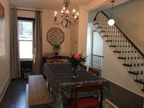 Enjoy meals in this dining area with a table set for four, featuring a tablecloth and a vase with flowers.