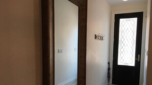 A hallway with a wooden door, a mirror, and a small rug. - Beautiful 4Br downtown garden house. Sleeps 12 (Toronto)