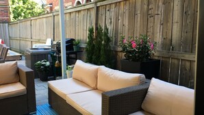 A patio area with wicker furniture, a grill, and potted plants. - Beautiful 4Br downtown garden house. Sleeps 12 (Toronto)