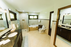 A bathroom with a large mirror, a sink, a toilet, and a bathtub. - Bohol Beach Club (Panglao)