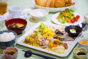 A table set with various dishes, including a plate of stir-fried vegetables and meat, a bowl of soup, and several side dishes.