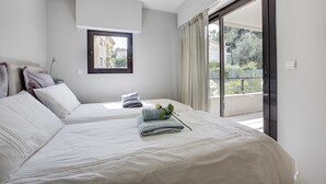 Camera d'albergo con due letti, una finestra e un balcone.