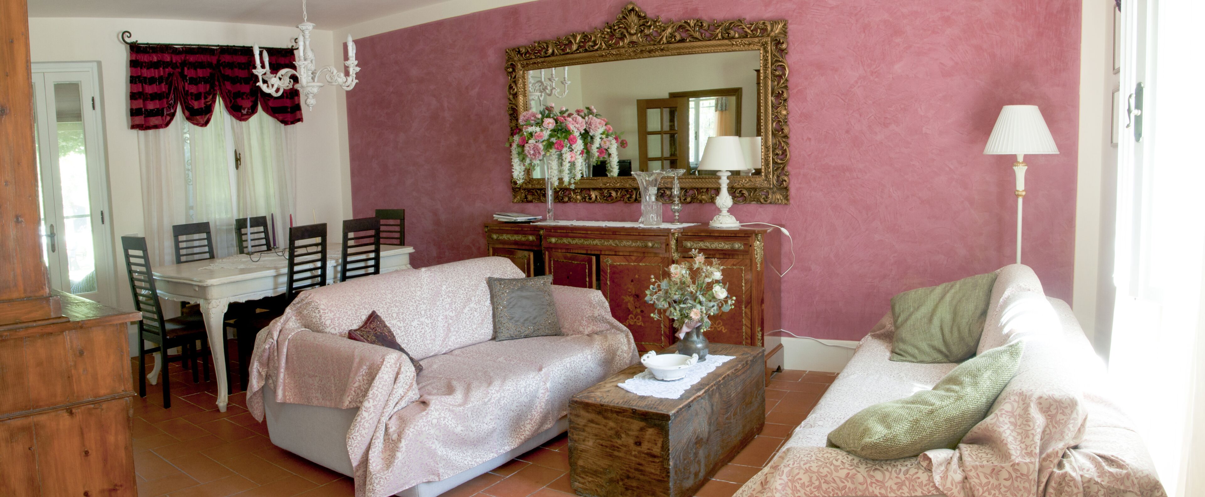 A living room with a sofa, a coffee table, and a dining area with chairs and a table.