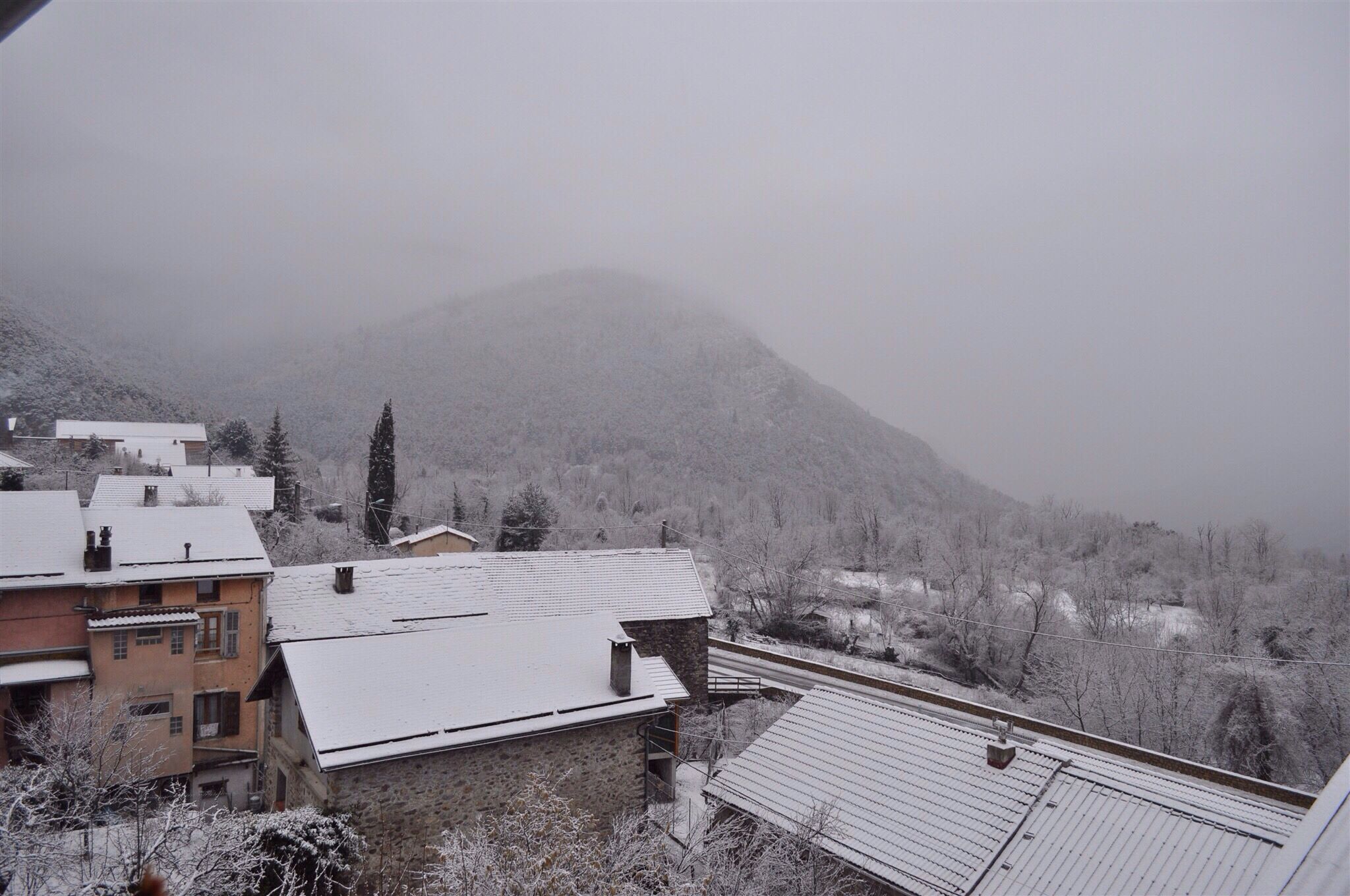 A snowy mountain landscape with buildings in the foreground.