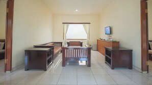 A room with a bed, a desk, a chair, and a TV.